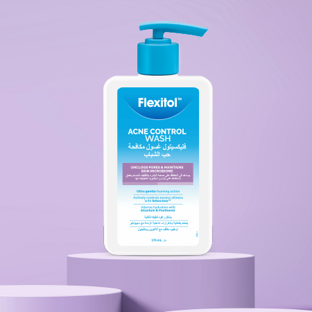 Flexitol Acne Control Wash bottle placed on a round display stand against a purple background